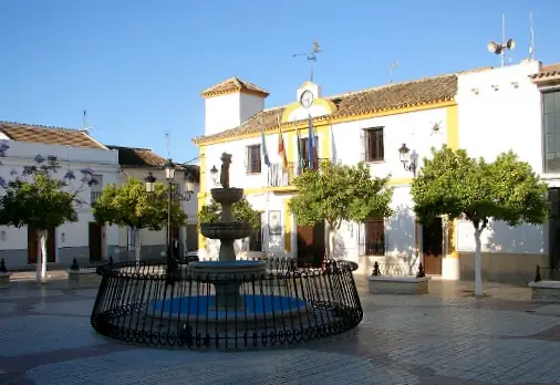 Fuente de la plaza del Ayuntamiento, con edificio del Ayuntamiento al fondo, en Aguadulce, Sevilla, España.
