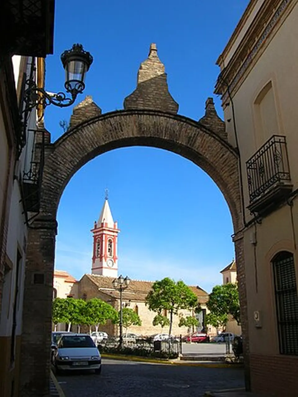 Calle de Castilleja de la Cuesta con un arco y la torre de la iglesia al fondo